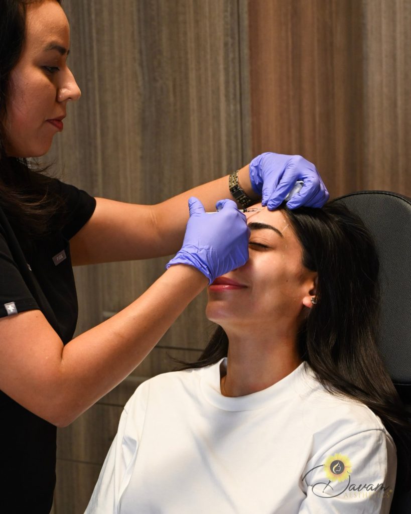 Woman getting Botox Injected in her forehead.